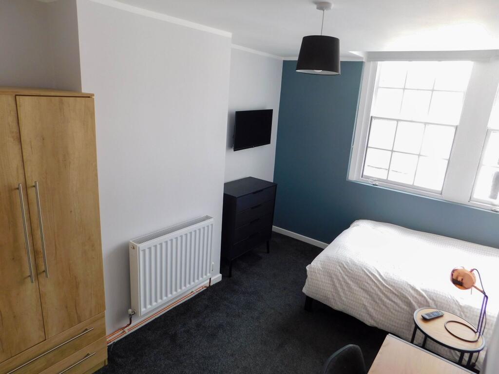 A bright and modern bedroom featuring a large w...