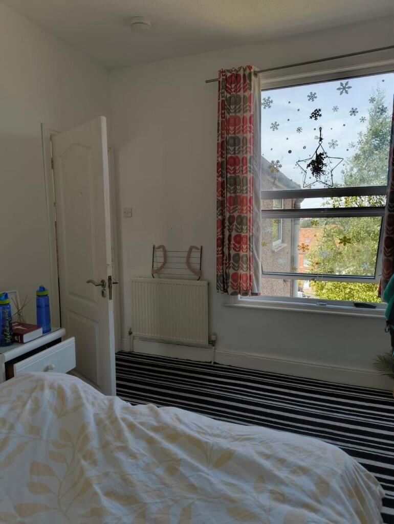 A cozy single bedroom featuring a large window ...