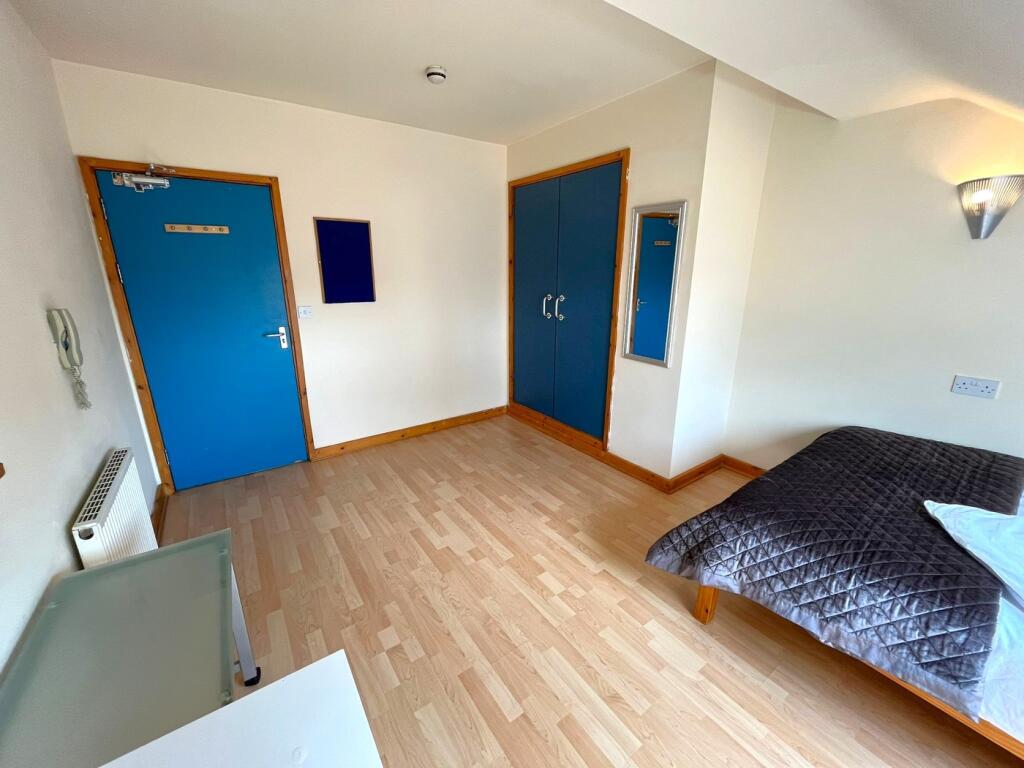 A spacious and well-lit double bedroom featurin...