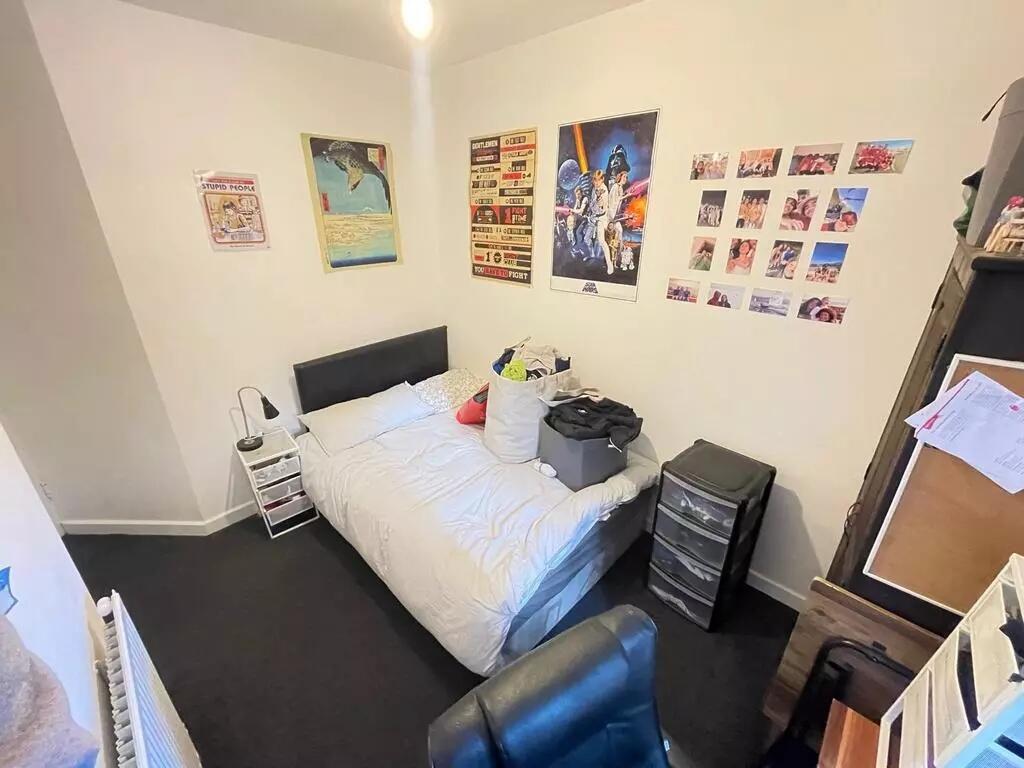 Cozy bedroom featuring a neatly made single bed...