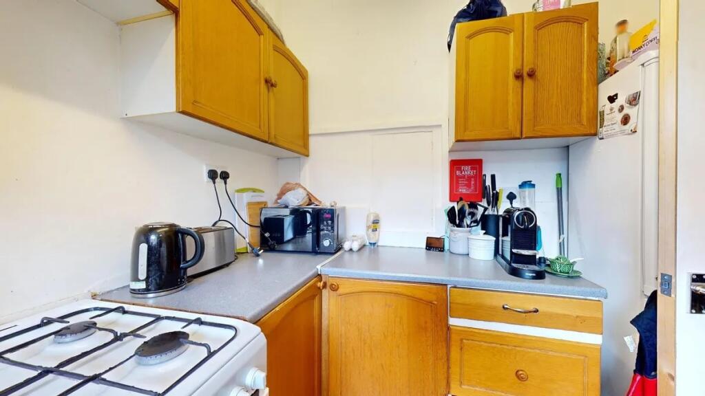 Compact kitchen featuring wooden cabinetry and ...