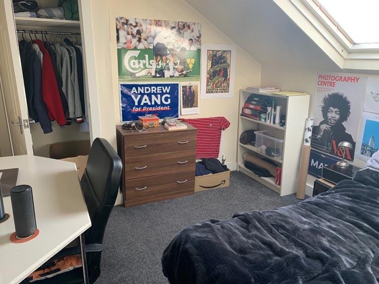 A cozy bedroom featuring a bed, study desk, and...