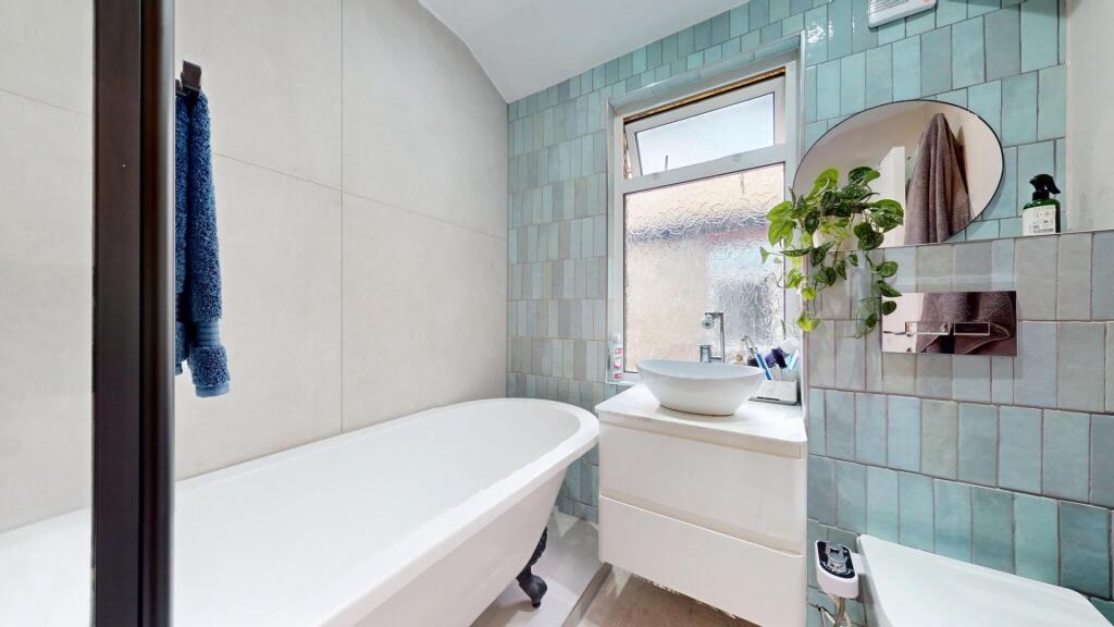 Bright and stylish bathroom suite featuring a c...