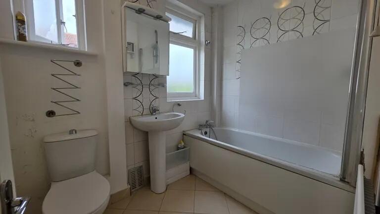 Bright and clean bathroom suite featuring a ful...