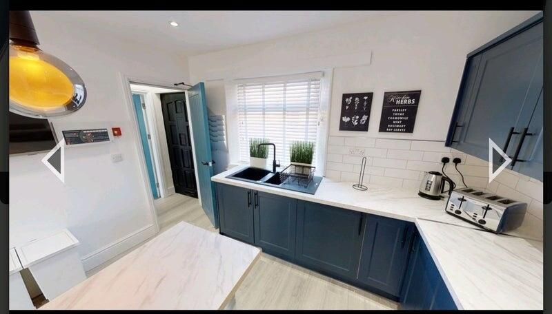 Bright and modern kitchen featuring navy blue c...