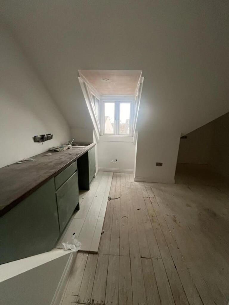 Spacious kitchen area featuring large windows t...