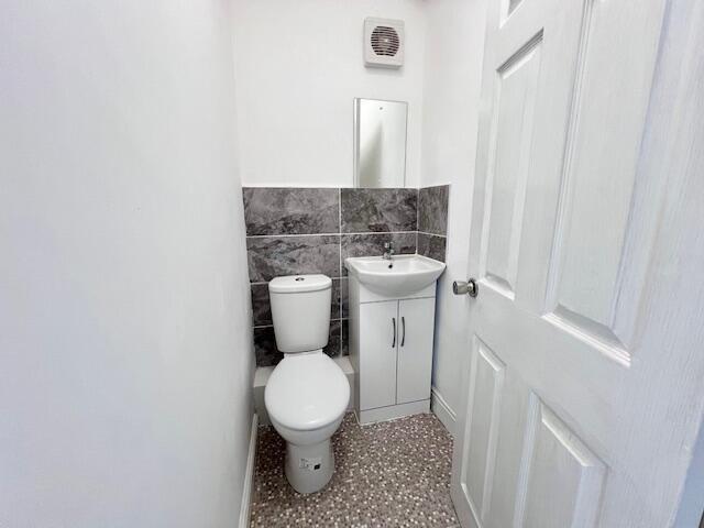 A clean and modern single toilet room featuring...