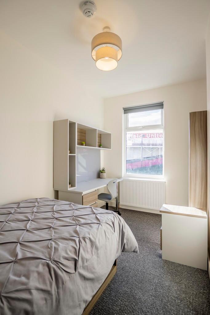 Bright and tidy bedroom featuring a comfortable...