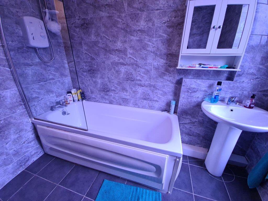 A modern bathroom featuring a clean white batht...