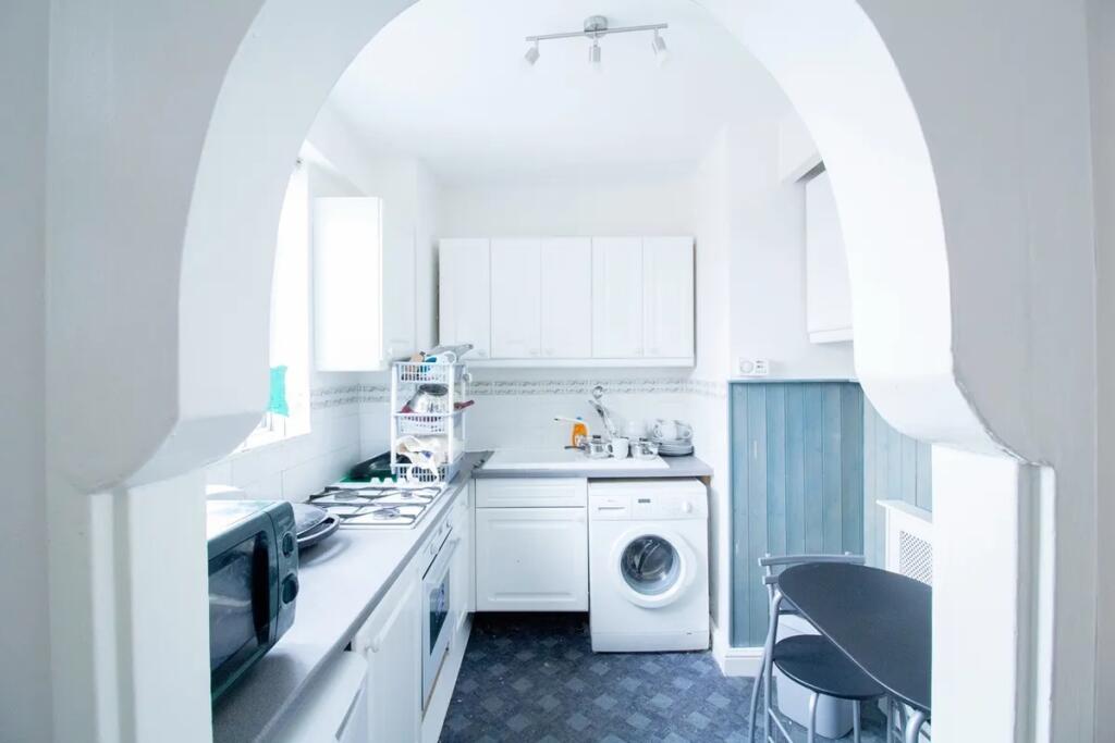 Bright and airy kitchen featuring clean white c...