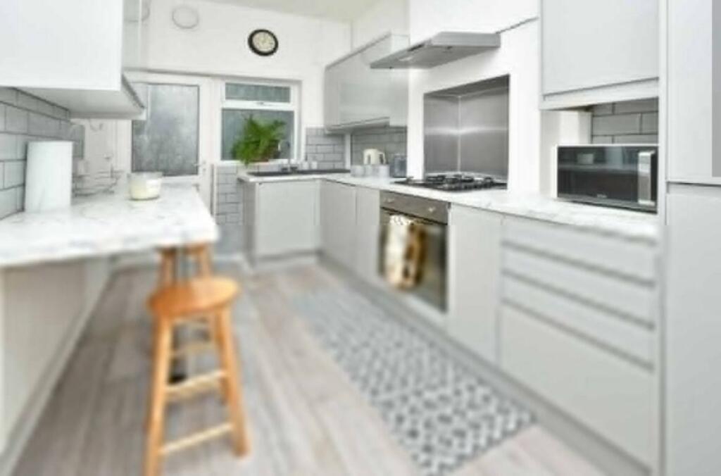 Modern and bright kitchen featuring sleek white...