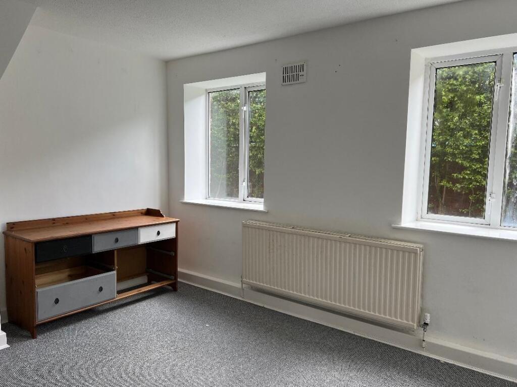 A bright and clean single bedroom featuring two...