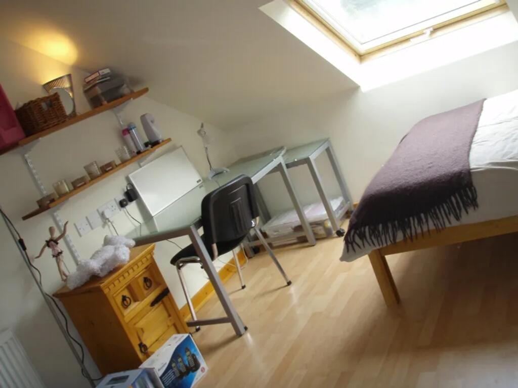 A cozy double bedroom featuring a desk, good na...