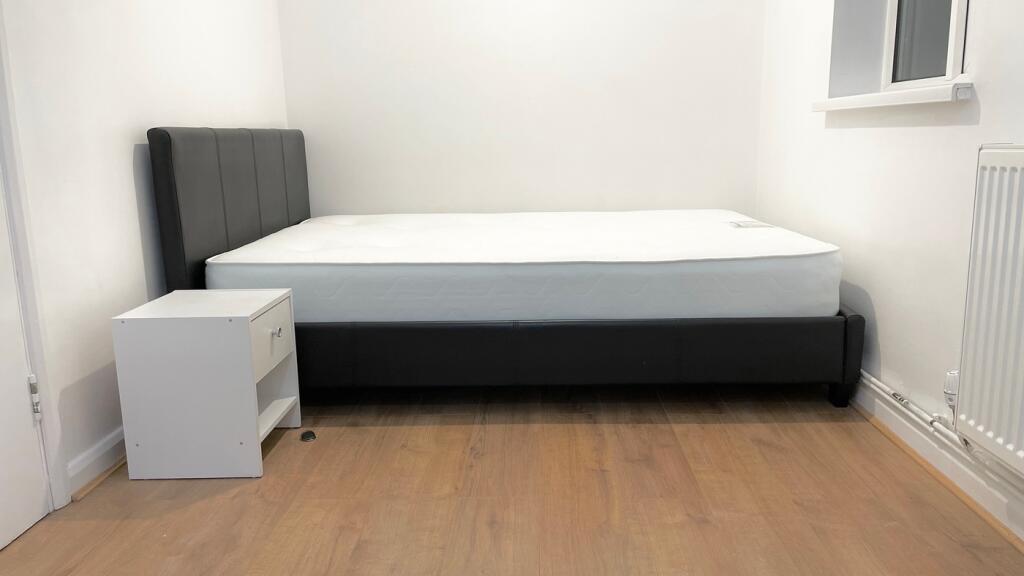 A cozy double bedroom featuring a modern bed fr...