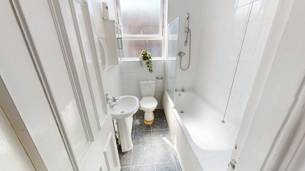 A bright and spacious bathroom featuring a bath...