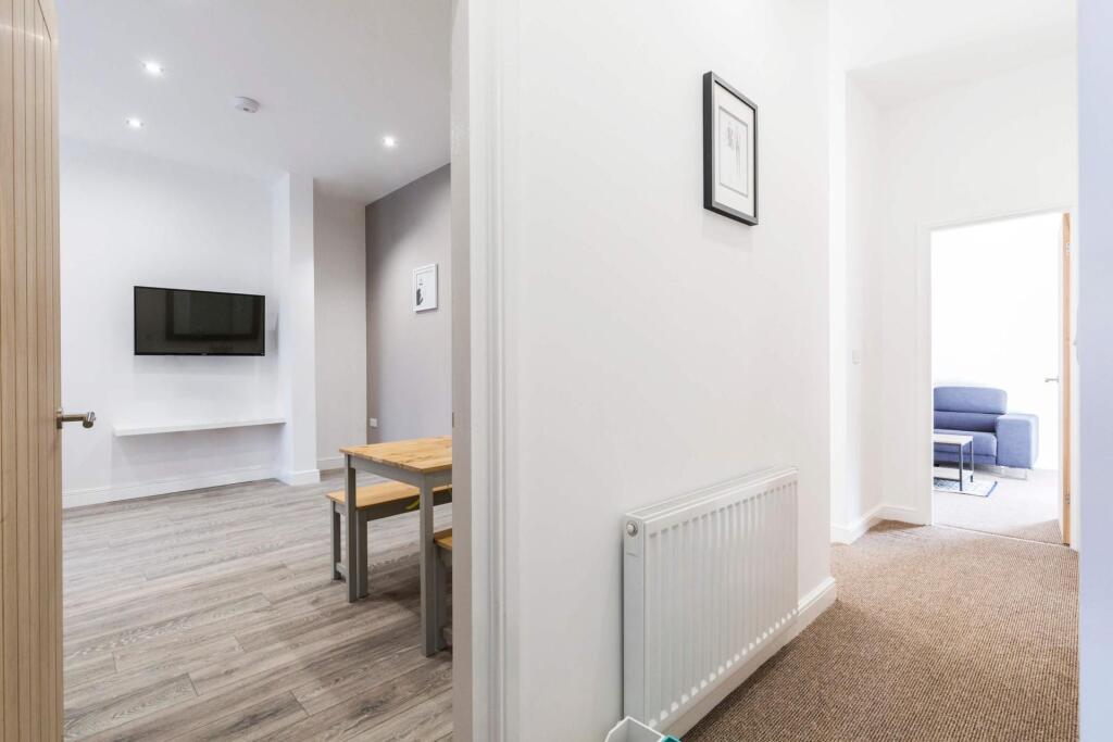 Bright, well-kept hallway with neutral decor le...