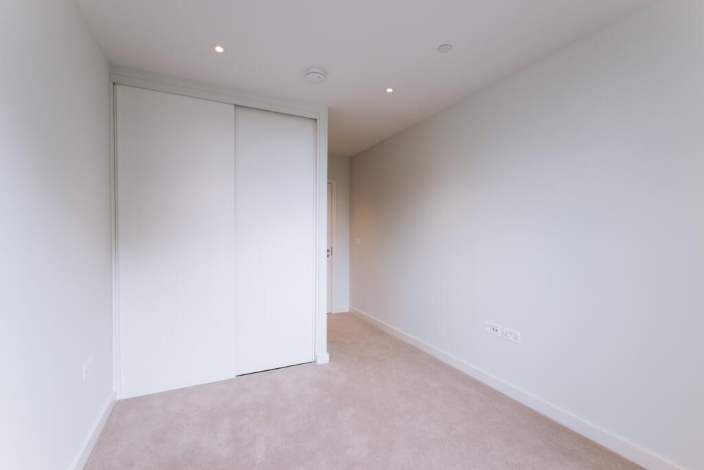 Experience tranquility in this bright, minimalist bedroom designed for relaxation.