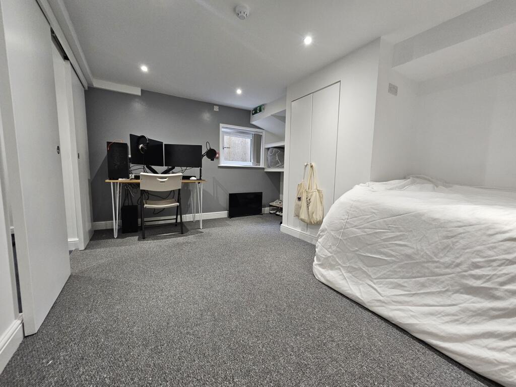 A tidy and well-lit bedroom featuring a large b...