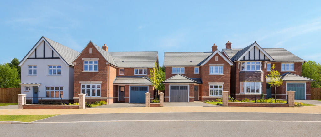 A row of modern detached houses with red brick exteriors, white and black timber detailing, and well