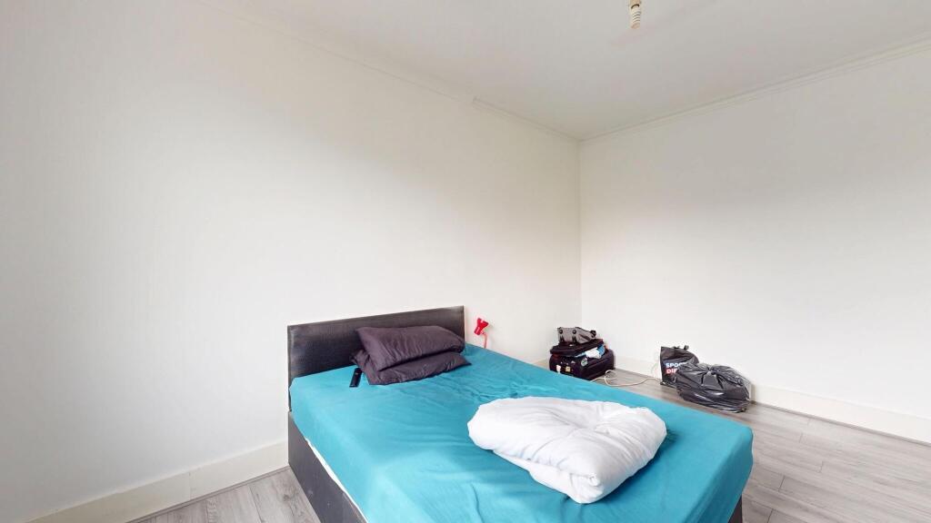 A well-lit double bedroom featuring a large bed...