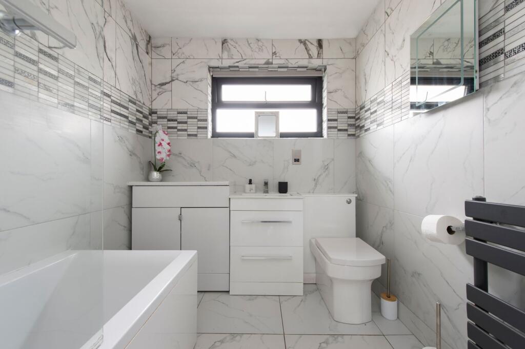 A pristine, modern bathroom featuring sleek whi...