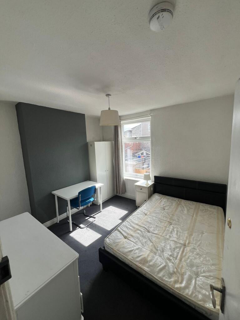 A bright double bedroom featuring a comfortable...