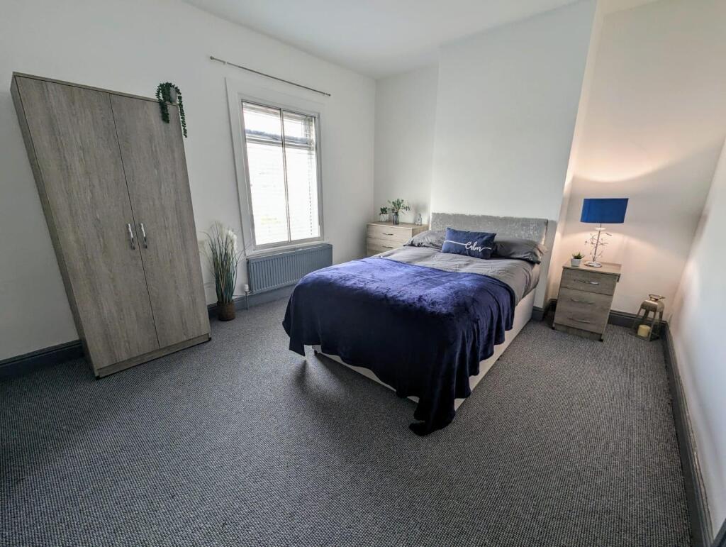 A clean and inviting double bedroom featuring a...