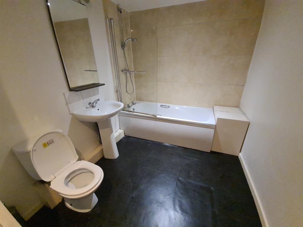 A spacious bathroom featuring a large bathtub, ...