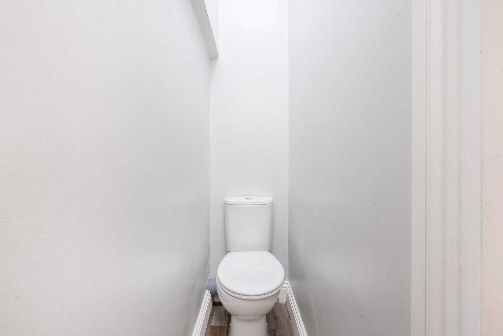 A clean and tidy single toilet area, featuring ...