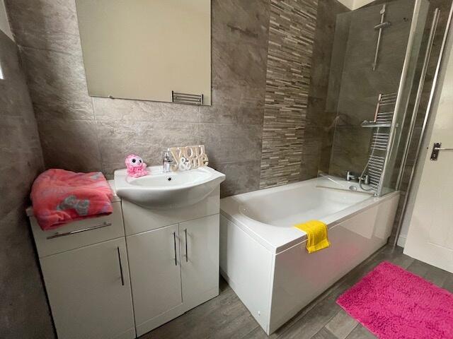 Modern bathroom featuring a spacious bathtub, s...