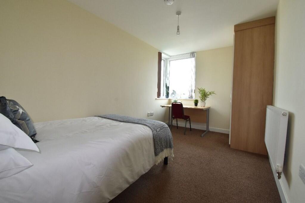 A bright and tidy single bedroom featuring a co...
