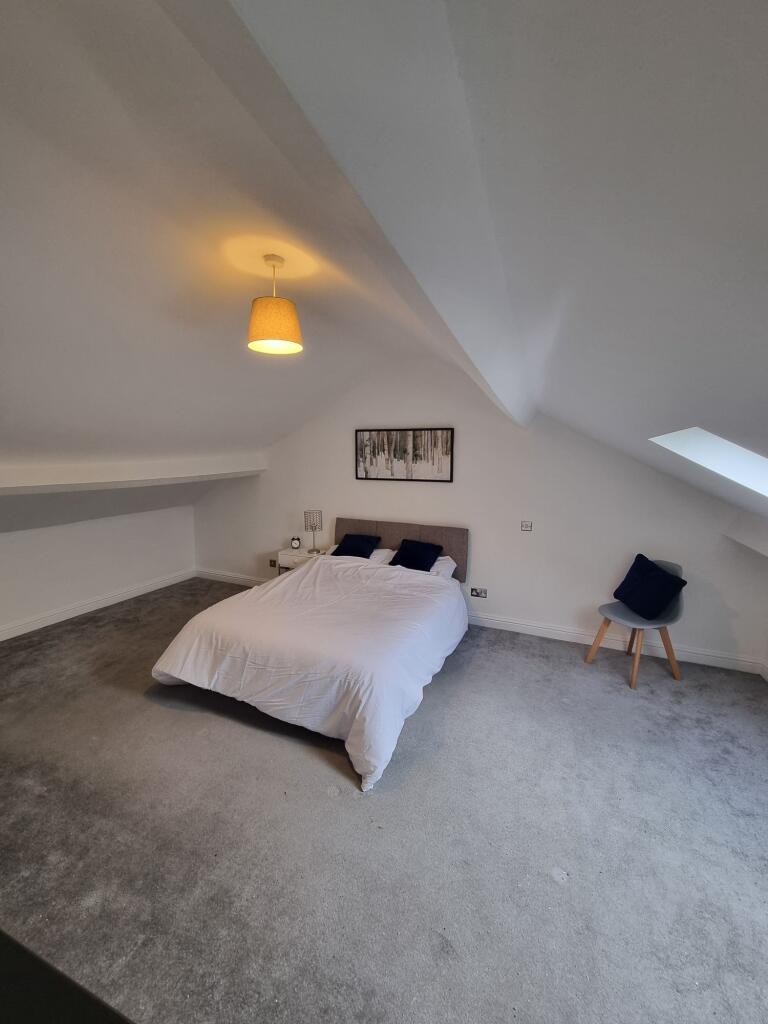 Spacious master bedroom with a large comfortabl...