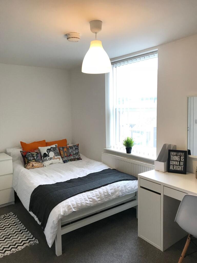 This inviting double bedroom features a cozy la...