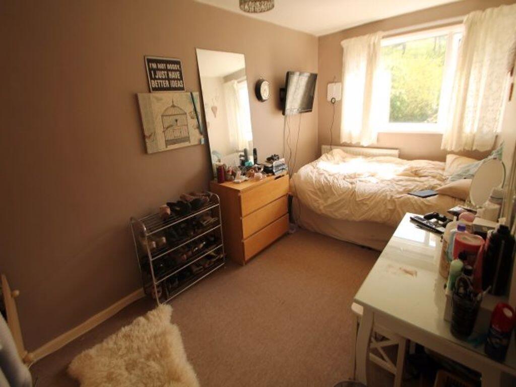 A cozy single bedroom with a comfortable bed by...