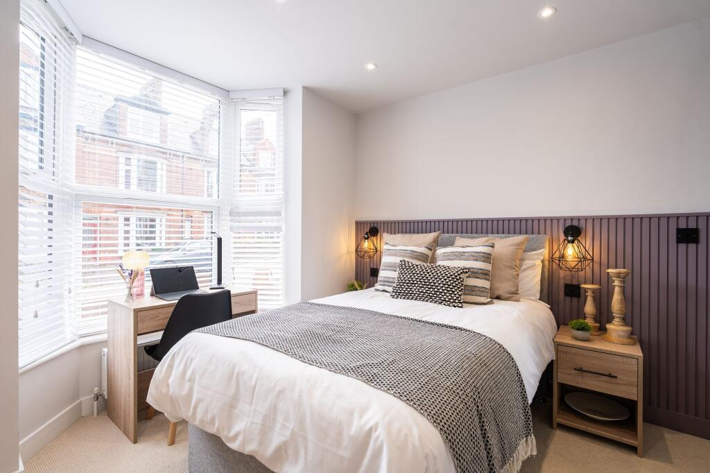 A stylish double bedroom featuring a comfortabl...