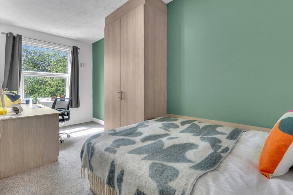 A bright and inviting single bedroom featuring ...