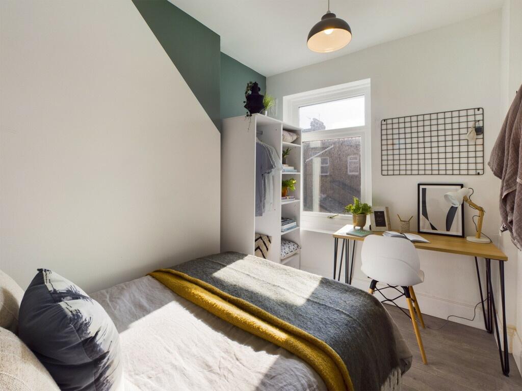 A modern, well-lit bedroom featuring a comforta...