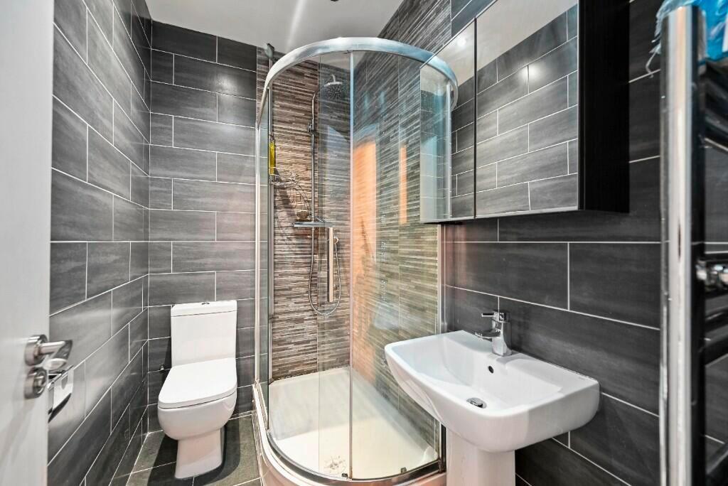 Modern bathroom featuring a sleek curved glass ...
