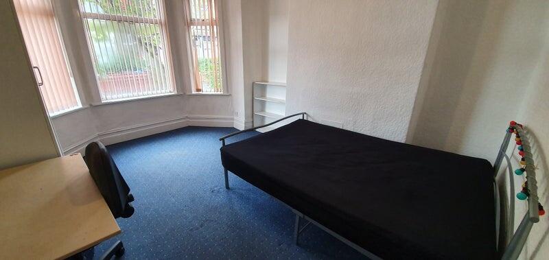 A bright single bedroom featuring a large bay w...