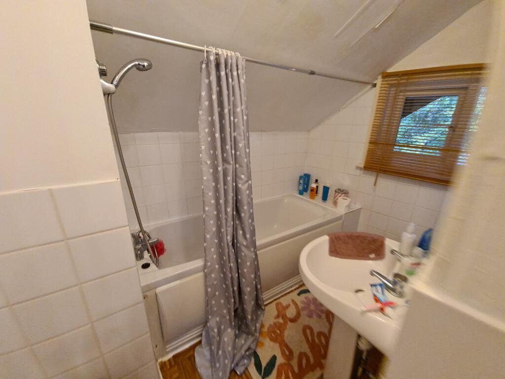 Compact, well-equipped bathroom with a shower-o...