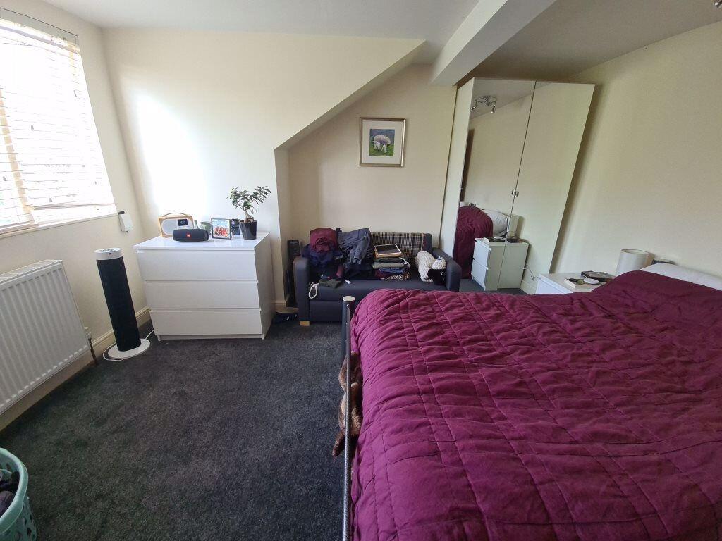 A spacious master bedroom featuring a large bed...