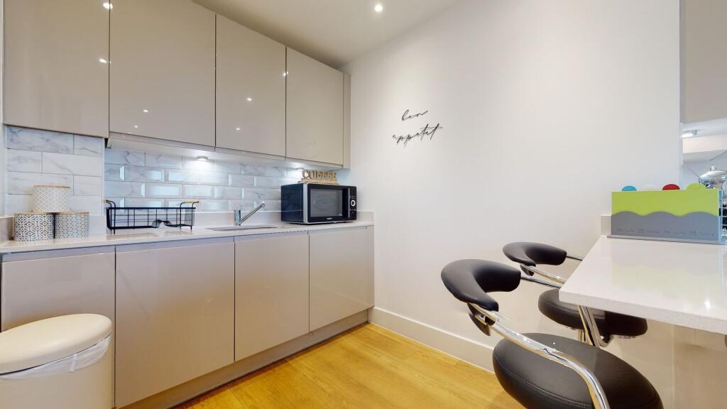 A modern, sleek kitchen featuring glossy cabine...