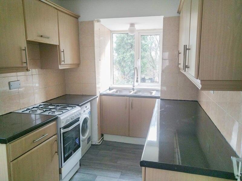 Bright and modern galley kitchen featuring ampl...