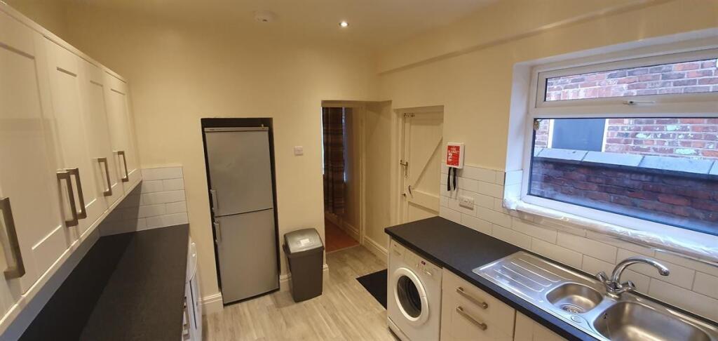 Bright, tidy galley-style kitchen with integrat...