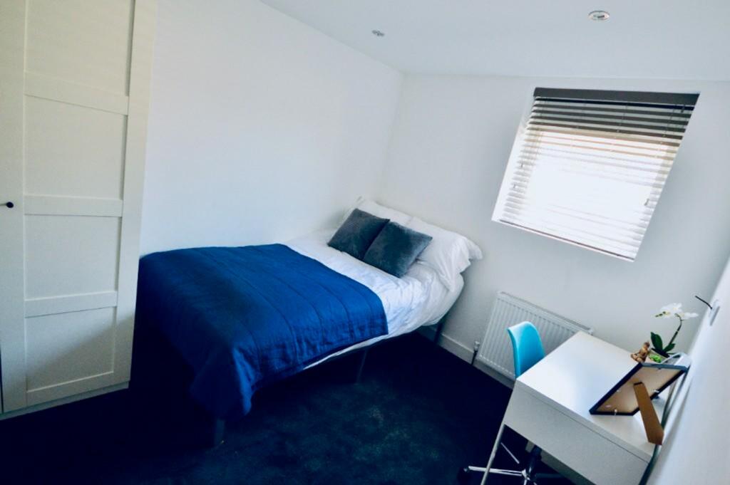 A bright and tidy double bedroom featuring a co...