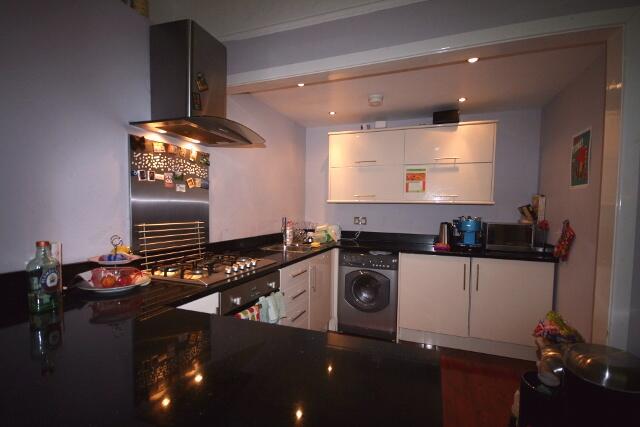 Modern, well-lit kitchen with sleek white cabin...