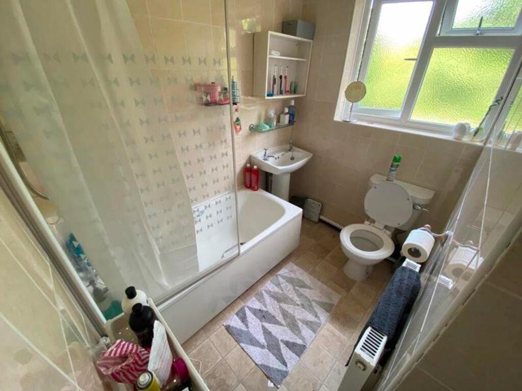 A spacious and clean bathroom featuring a bath ...