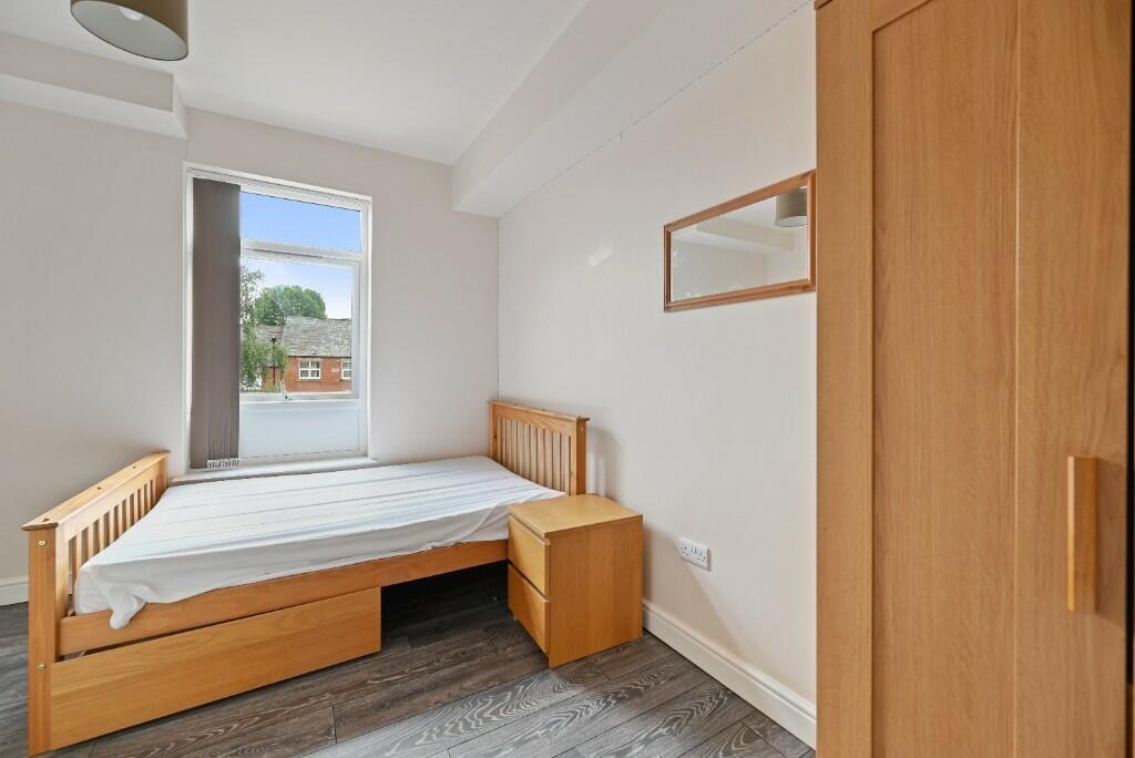 A neat and bright single bedroom featuring a wo...