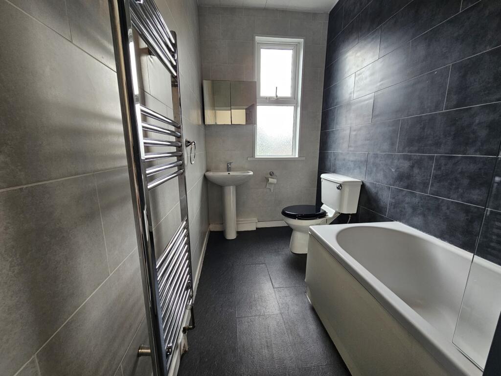 A modern bathroom featuring a deep white bathtu...