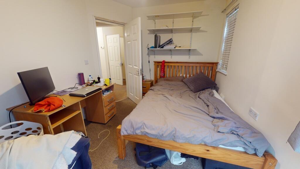 A compact, well-lit bedroom featuring a single ...